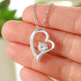 Beautiful Forever Love necklace with free gift box and heartfelt message saying To my beautiful wife, in your arms is the only place I know where peaceful waters flow. I loved you when we met, I still love you now, I'll love you forever. Love your husband. High polished heart pendant surrounding a flawless 6.5mm Cubic Zirconia, embellished with smaller Cubic Zirconia adding sparkle and shine. The pendant is available in 14k White Gold finish or 18k Yellow Gold finish