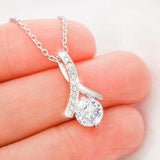 This beautiful sparkly pendant is truly is an alluring gift for your Wife, Daughter, Granddaughter, Bride To Be, Girlfriend or even for yourself. The emotions will start pouring out along with tears of joy. Comes with a Free Luxury Gift Box with the Heart Felt message as shown. The ribbon design is embellished with dainty cubic zirconia, leading your eye down to the 7mm round cut Cubic Zirconia. Crafted with 14k White Gold over Stainless Steel