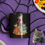 Black 11 ounce coffee mug for Halloween with pumpkin and cats on it