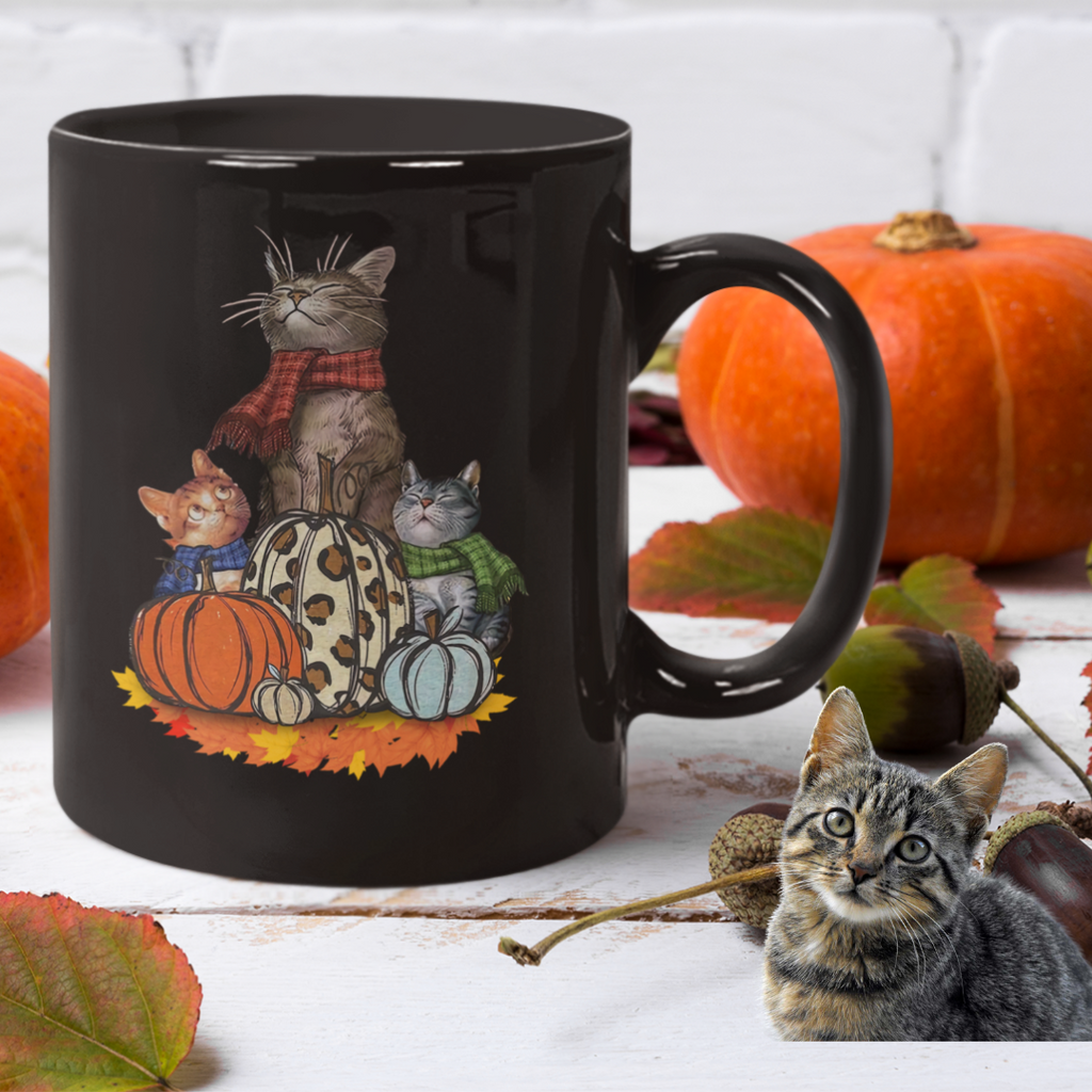 Black 11 ounce coffee mug for Halloween with pumpkin and cats on it.